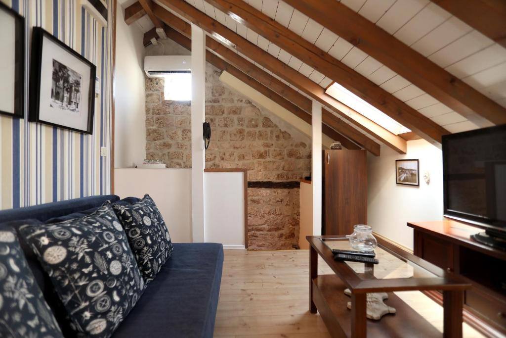 Attic living room with timber beams and stone wall