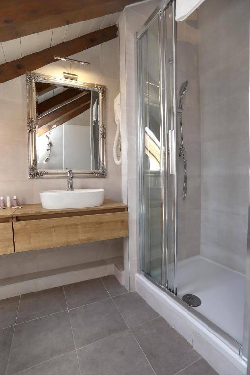 Bathroom under timber beams with framed mirror